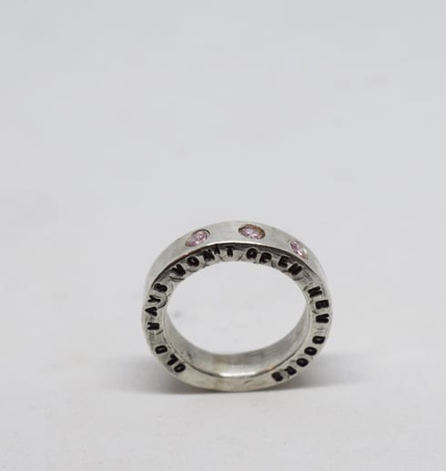 Silverring med text och stenar